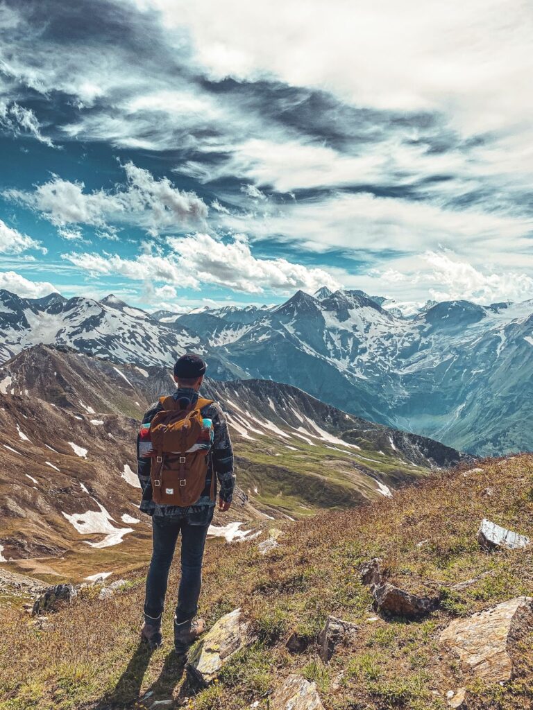 Турист стоїть на фоні гір.