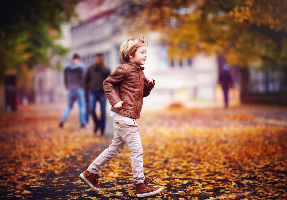 Хлопчик біжить у коричневому шкіряному взутті.